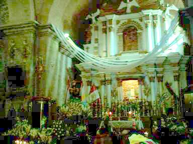 Altar principalarrreglado con flores y ceras